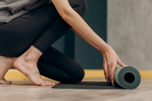 Image of a person rolling out a yoga mat