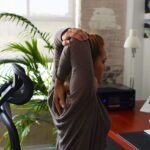 A woman stretching at her desk
