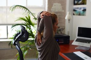 A woman stretching at her desk