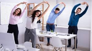 a man and a woman stretching at a desk