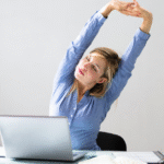 A woman stretching at her desk