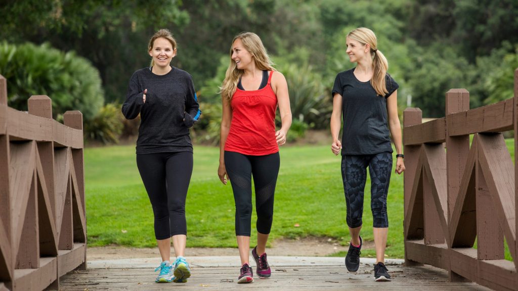 3 woman walking across a bridge