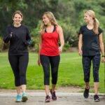 3 woman walking across a bridge