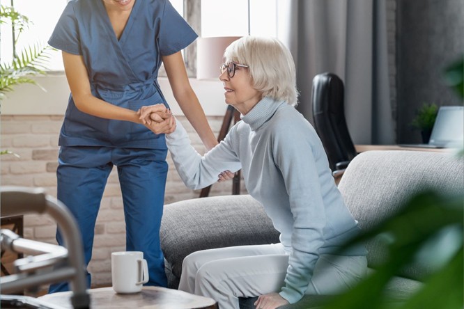 A senior woman getting help from an aid