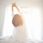 A woman waking up and stretching