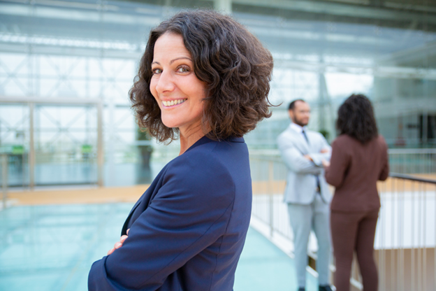 A woman standing with her arms crossed and smiling.