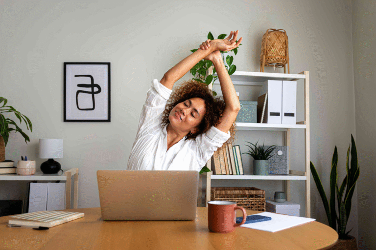 A woman stretching at her desk.