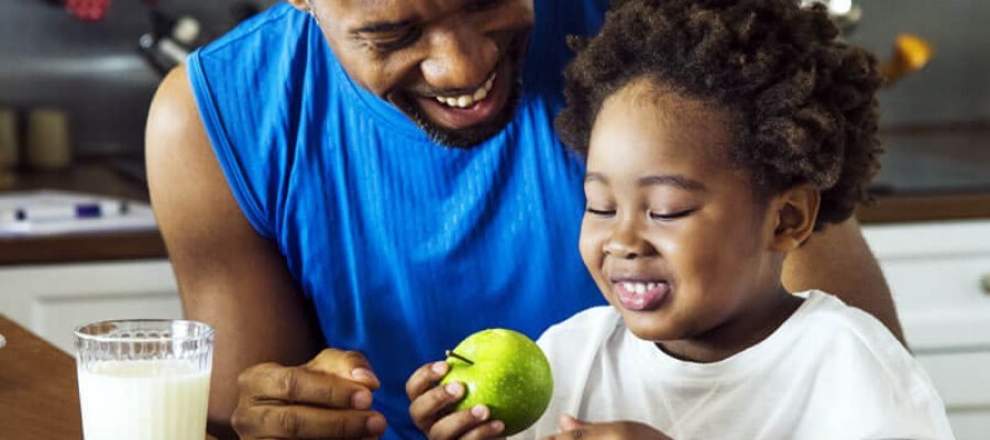 A man and child at a counter with food