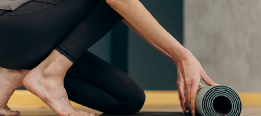 Image of a person rolling out a yoga mat