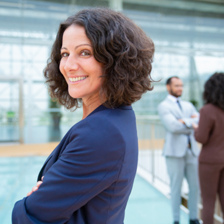 A woman standing with her arms crossed and smiling.