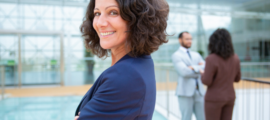 A woman standing with her arms crossed and smiling.