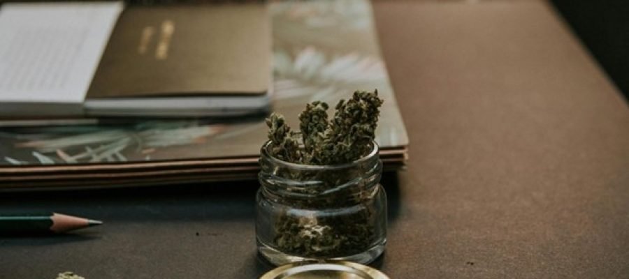 A small glass jar with a plant in it