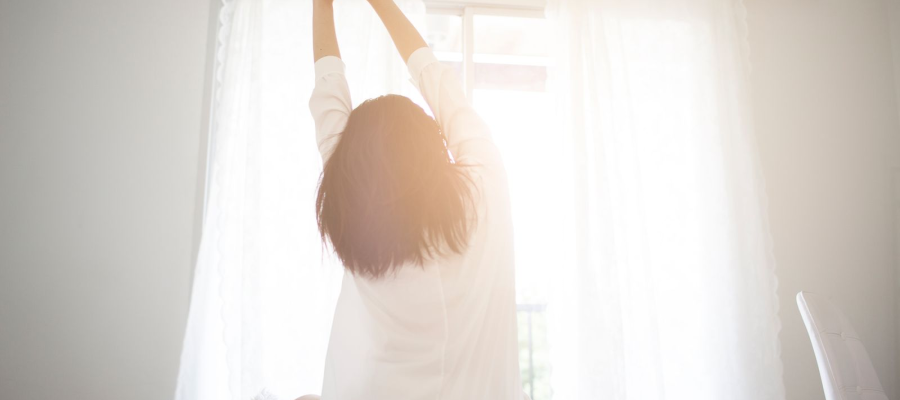 A woman waking up and stretching